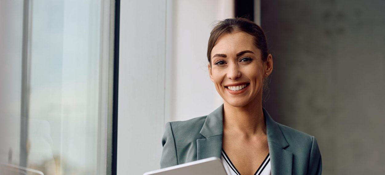 Happy,Female,Entrepreneur,Using,Touchpad,While,Working,In,The,Office